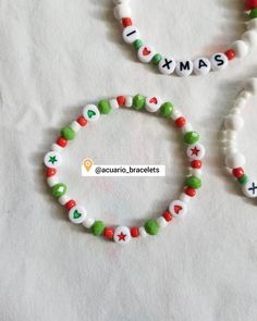 three bracelets with beads and letters that spell out the word christmas on white paper