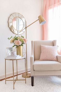 a living room with a chair, mirror and flowers on the table in front of it