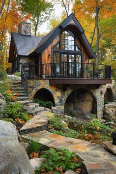 a house in the woods surrounded by rocks and trees with lots of leaves on it