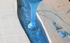 a blue liquid pouring out of a piece of wood