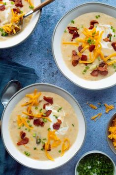 three bowls of soup with bacon, cheese and sour cream in them on a blue surface