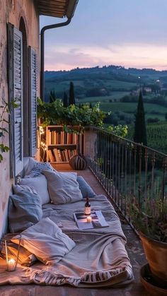 an outdoor bed on the outside of a building with a view of rolling hills in the distance