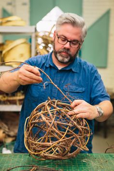 a man working on a bird nest in a shop