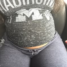 a woman sitting in a car seat with her stomach exposed