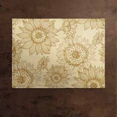 a placemat with sunflowers on it sitting on top of a wooden table