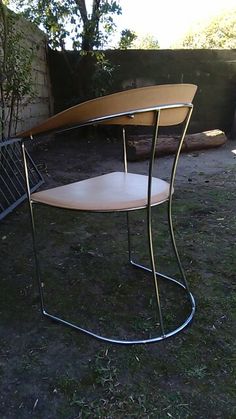 two wooden tables sitting on top of grass next to a metal fence and tree trunk