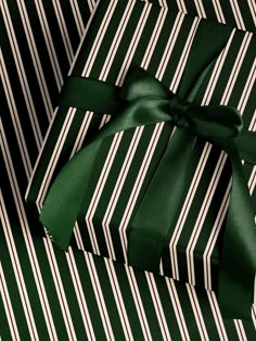 a green and white striped gift box with a bow