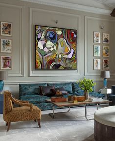 a living room filled with furniture and paintings on the wall