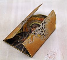 a small card holder with an image of jesus on it's face and a pair of scissors sticking out of it