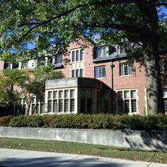 a large brick building with many windows and trees