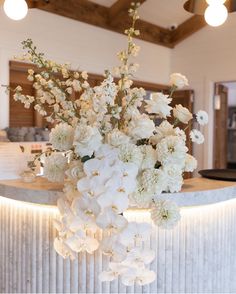 a vase with white flowers sitting on top of a counter