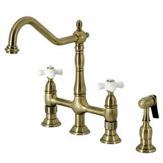 an antique brass faucet with three white knobs