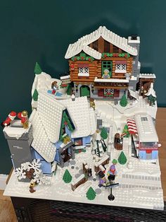 a lego model of a small town with snow and christmas decorations on the top of it