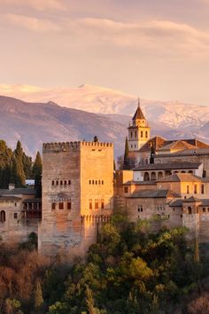 an old castle with mountains in the background