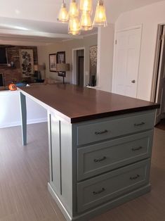 a kitchen island with lights hanging over it