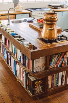 a kitchen island with books on it in front of a sink