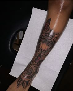 a person with a tiger tattoo on their arm and leg next to a piece of paper