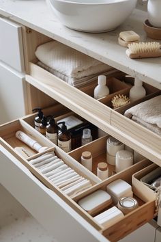 an open drawer with various items in it and a bowl on the counter behind it