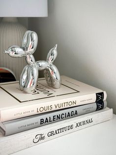 three books stacked on top of each other in front of a lamp and bookend