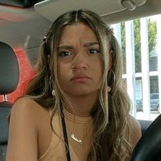 a woman sitting in the back seat of a car with her hand on her hip