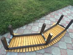 a wooden bench sitting on top of a stone walkway