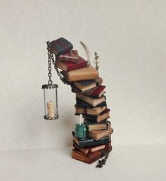 a stack of books with a candle hanging from it