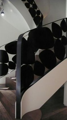 a spiral staircase with black and white decorations on the bottom handrail in a modern building