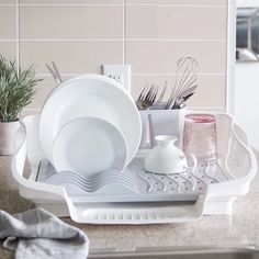 a dish rack with dishes and utensils in it