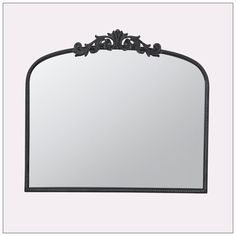 a mirror with an ornate design on the top and bottom frame, hanging from a white wall