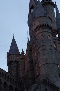 the castle is lit up at night with lights on it's towers and windows