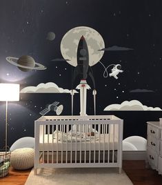 a baby's room with a rocket ship mural on the wall and space themed walls