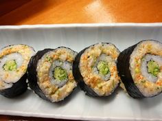 four sushi rolls are arranged on a white plate