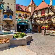 the entrance to an amusement park with lots of flowers