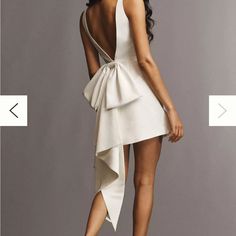 the back of a woman's white dress with an asymmetrical bow