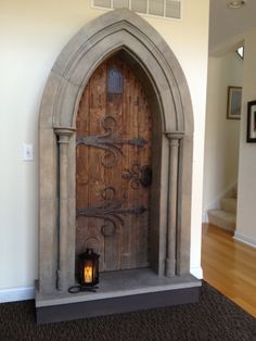 a wooden door with a lantern in front of it on the floor next to a wall