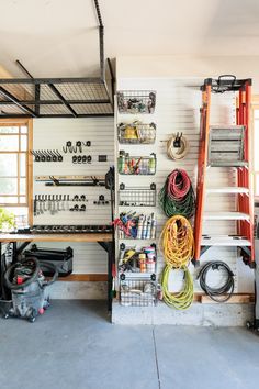 the garage is filled with various tools and equipment, including hoses hanging on the wall