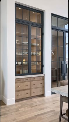 an empty dining room with wooden furniture and glass doors