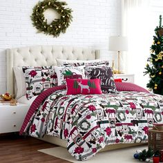 a christmas themed bed in a white room with red and green decorations on the pillows