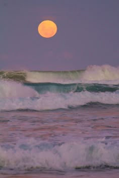 the moon is setting over the ocean waves