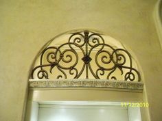 an arched window with decorative iron work on it