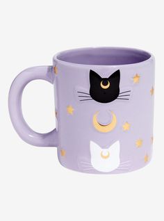 a purple coffee mug with a cat's face painted on the side and stars around it