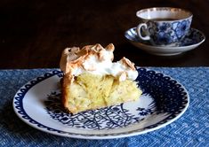 a piece of cake sitting on top of a blue and white plate next to a cup