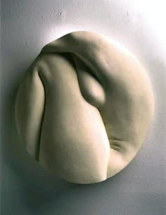 a white sculpture is hanging on the wall