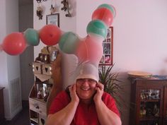 a man sitting at a table with balloons on his head