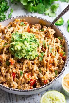 a bowl filled with mexican food and garnished with guacamole