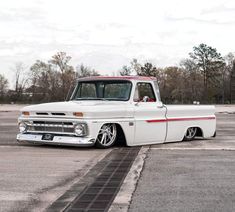 an old white truck parked in a parking lot