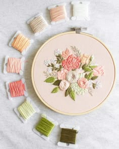 a close up of a embroidery on a table with many different colored thread spools