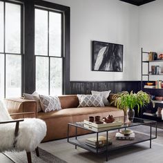 a living room filled with furniture and lots of windows