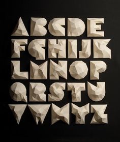 the letters are made out of white origami paper and placed on a black surface