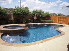 an outdoor swimming pool surrounded by landscaping